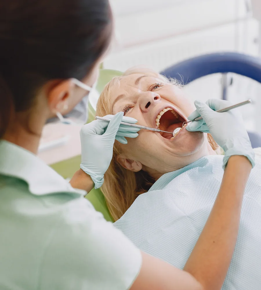 Dentista atendendo paciente em consultório moderno e iluminado (imagem ilustrativa)